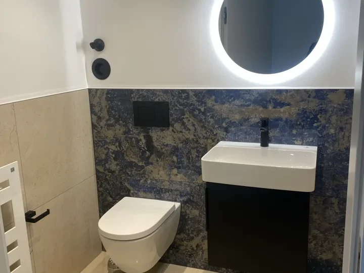 Gäste-WC mit Naturstein und Rundspiegel